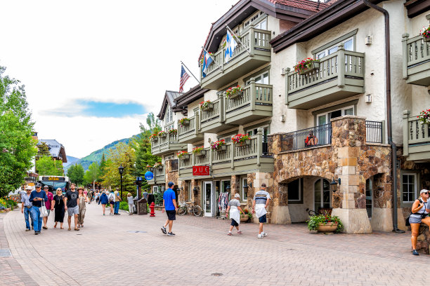 在科罗拉多滑雪胜地，人们在市中心梅多驱车行驶街道，巴士经过商店和商店图片下载