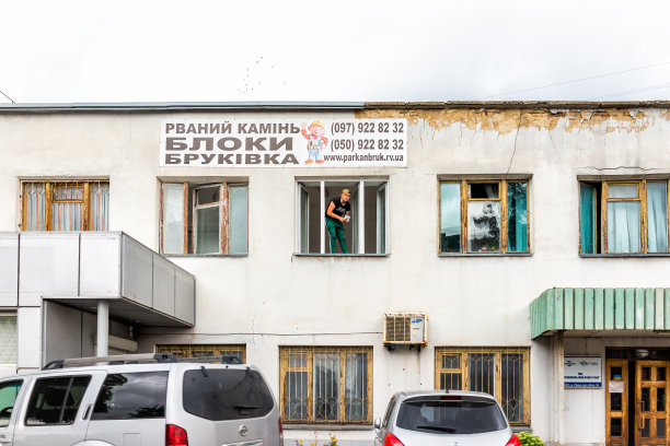 乌克兰城市罗夫诺与标志旧建筑为破碎的石头岩石路面水泥和妇女在窗口图片下载