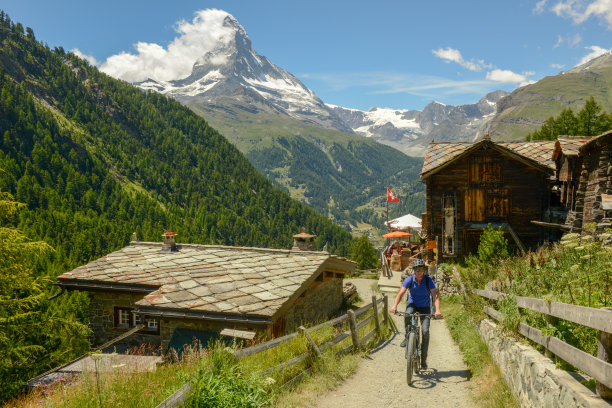 在瑞士阿尔卑斯的策马特，一名男子驾驶山地摩托车在小道上行驶图片下载