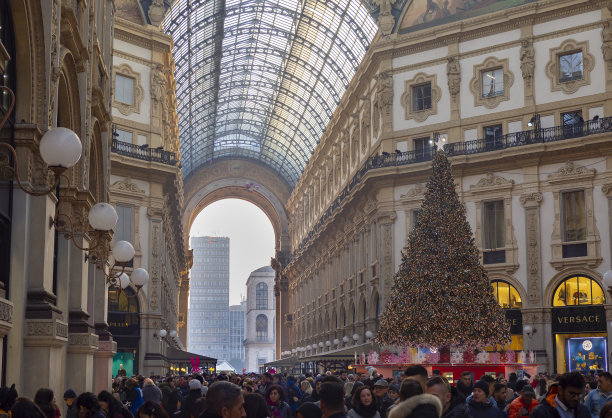 米兰,意大利。著名的维托里奥·埃马努埃莱二世购物中心是米兰的主要地标之一。圣诞节的时间。人群和游客。圣诞彩灯和装饰品图片下载