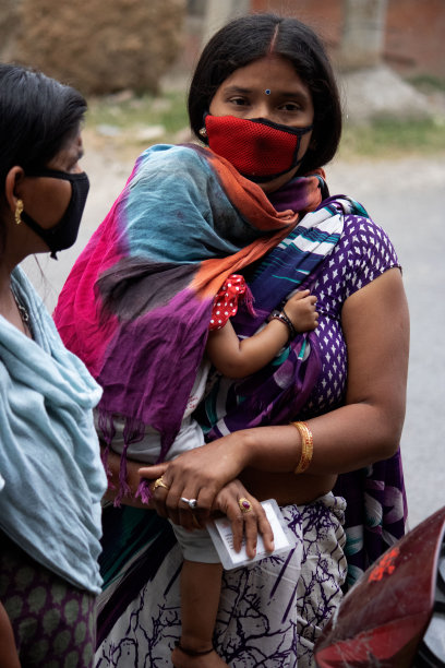 带着孩子的妇女戴着口罩。图片下载