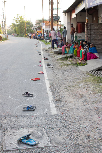 人们坐在一旁，把拖鞋放在那里围成圈。图片下载