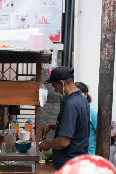 雅加达街头小吃，一名男子在路边卖鸡肉面条。图片下载