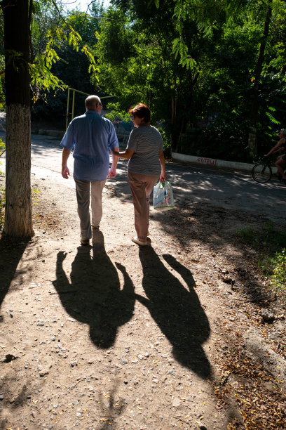 一对老夫妇手牵着手在敖德萨的一个公园里散步。图片下载