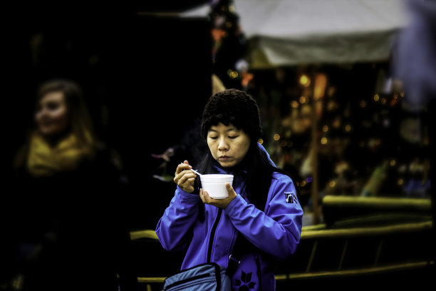 一名亚洲女性在广场中心享用汤的街头照片图片下载