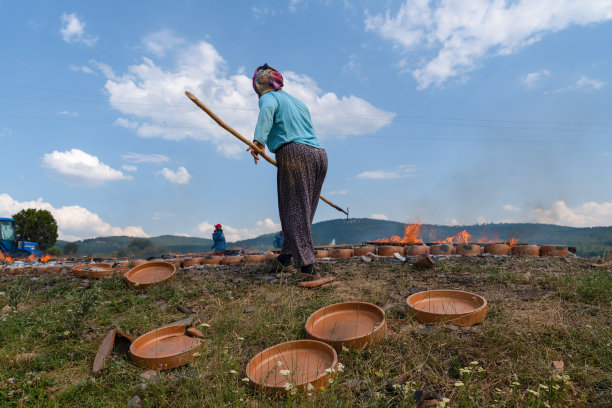 后视图的妇女工人干燥粘土陶器通过燃烧在地面上在露天。Mihaliccik,埃斯基谢希尔/土耳其图片下载