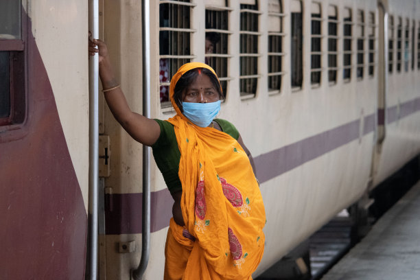 女人们戴着面具站在火车外，面对着摄像机。图片下载