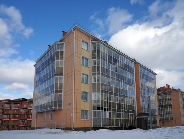 克拉斯诺亚尔斯克地区Tayozhny村的新住宅砖砌公寓大楼，带有玻璃阳台，矗立在雪中。俄罗斯。图片下载