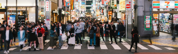 在歌舞伎町红灯区，熙熙攘攘的亚洲人的身影在晃动。日本夜生活文化，东京标志性旅游景点，或日本旅游概念。横幅尺寸图片下载