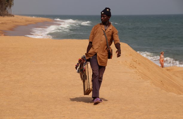 西非多哥阿韦波佐海滩上，一名海滩小贩正在兜售纪念品。图片下载