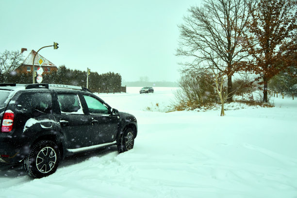 达契亚防尘越野车，车辆的罗马尼亚制造商在深雪旁边的道路图片下载