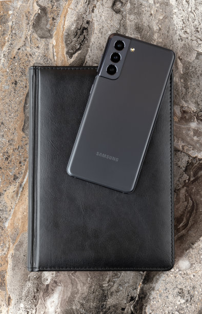 大理石桌上放着三星Galaxy S21。三星的新款智能手机和一本日记本特写。图片下载