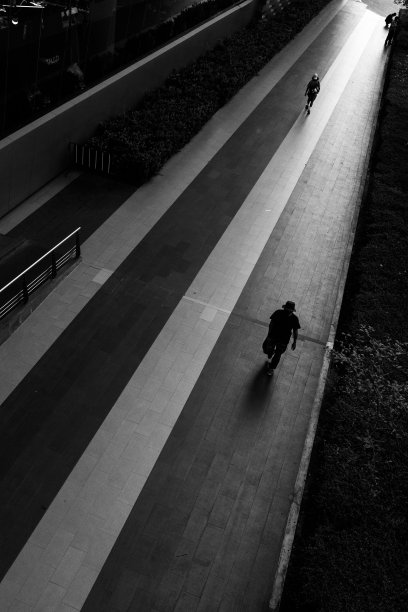 两名泰国人走在大楼前的人行道上。图片下载