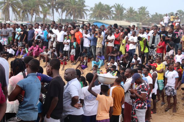 在西非多哥Lomé的公共海滩上，许多人在观看球类比赛。图片下载