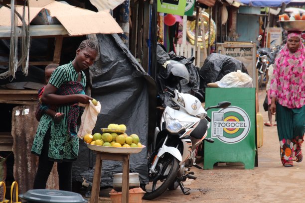 妈妈卖橘子，背着一个婴儿。位于西非多哥Kpalimé的小型家族企业。图片下载