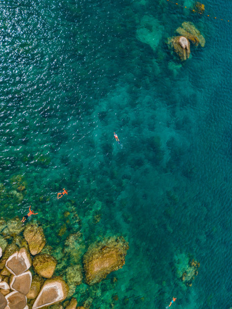 男人和女人在大海里游泳。无人机航拍照片图片下载
