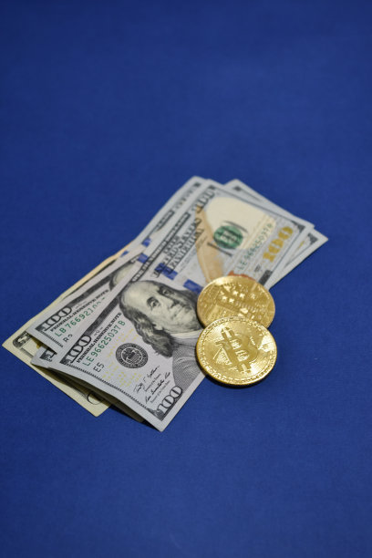 黄金比特币以闪烁的灯光为背景，加密货币概念。用于网上银行和国际支付的电子虚拟货币。折叠在一个管100美元纸币。散焦照片图片下载