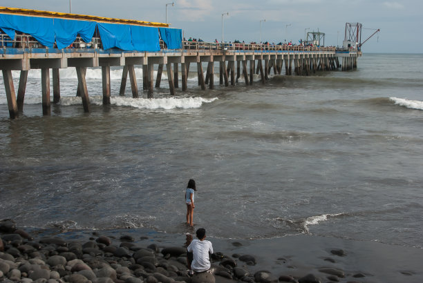 在一个暴风雨的夜晚，人们聚集在萨尔瓦多的拉利伯塔德港向渔民们购买鱼。图片下载