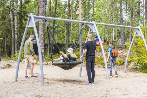 炎炎夏日，父母带着孩子在儿童游乐场里放松。欧洲。图片下载