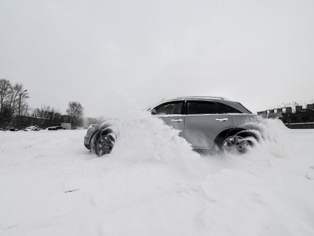 汽车英菲尼迪QX70，冬天开车穿过雪堆时的汽车照片。图片下载