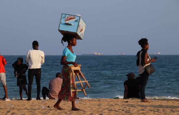 在西非多哥Lomé的海滩上，一名妇女头上顶着冰淇淋。图片下载