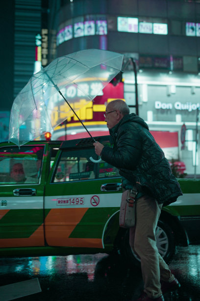 一个日本老人与绿色出租车下着雨图片下载
