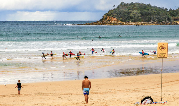 年轻的男孩和女孩们用冲浪板冲进水里图片下载