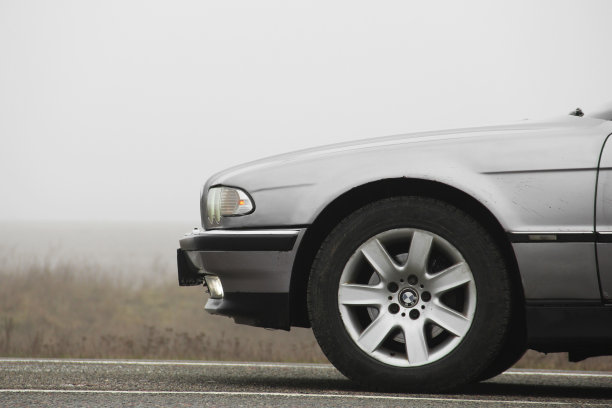 老爷车宝马7系(E38)在雾背景下行驶。阴郁的天气。宝马和雾图片下载