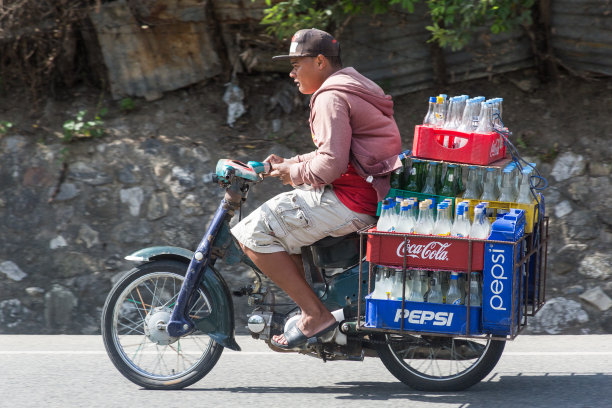 多米尼加共和国加勒比小镇上骑摩托车的男人图片下载