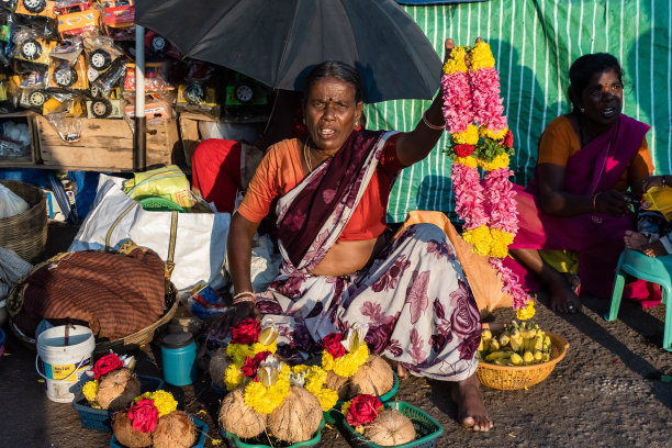 一个印度女人卖彩色花朵的肖像图片下载