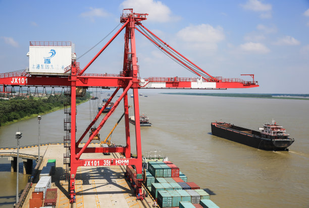 在苏州工业园区九江港外贸码头，工人们操作自动化起重机装卸集装箱。图片下载