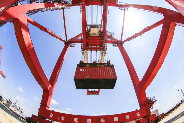 在苏州工业园区九江港外贸码头，工人们操作自动化起重机装卸集装箱。图片下载