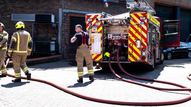 消防车和消防员在公共停车场救火图片下载