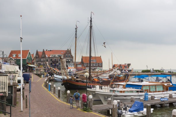 游客们在阿姆斯特丹东北部的马克米尔湖上的小镇Volendam游览，这里以五颜六色的木屋和古老的渔船而闻名。图片下载