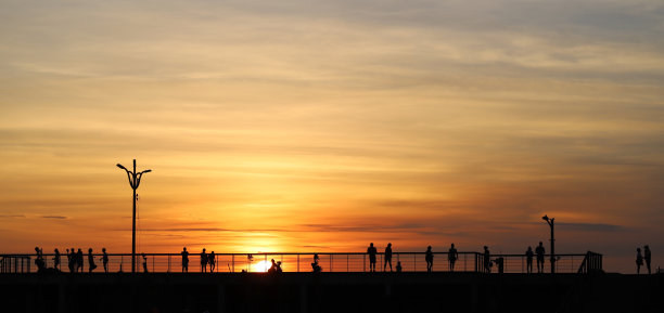 夕阳下人们的剪影。图片下载