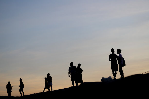夕阳下人们的剪影。图片下载