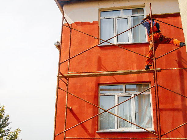 在脚手架平台上给建筑物染色的油漆工图片下载