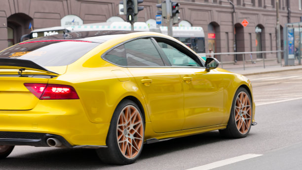 黄色跑车行驶在塔林市中心的道路上图片下载