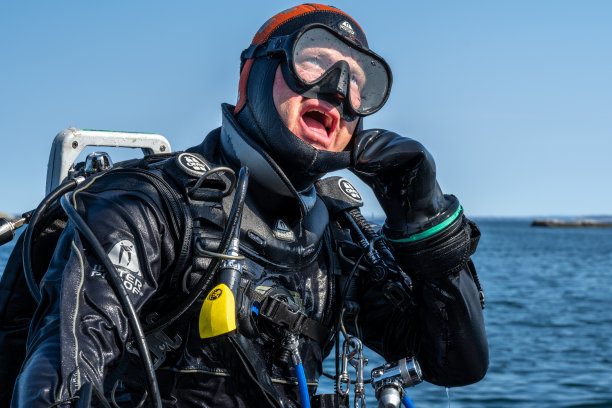 这是潜水员等待潜水船就位的特写照片，这样他就可以下水了。背景是海洋和蓝天图片下载