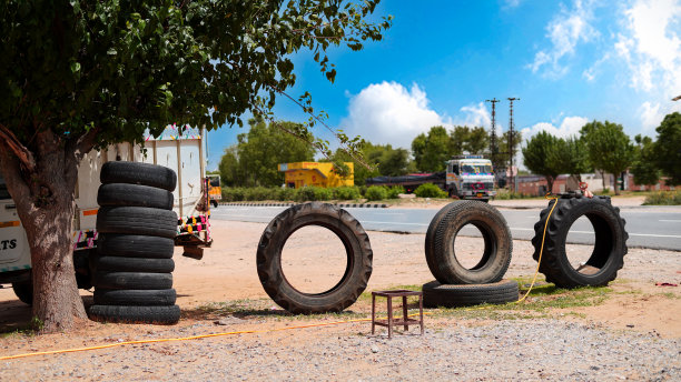 多云的天空和公路景观。许多轮胎在国家公路外。图片下载