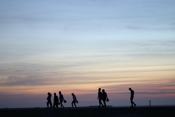 夕阳下人们的剪影。图片下载