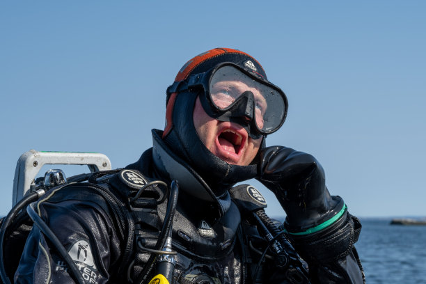 这是潜水员等待潜水船就位的特写照片，这样他就可以下水了。背景是海洋和蓝天图片下载