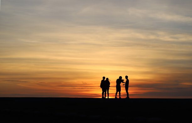 夕阳下人们的剪影。图片下载