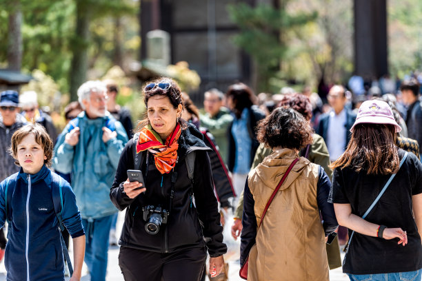 白天，游客们在东大寺门口散步，拍摄家庭照片的女人图片下载