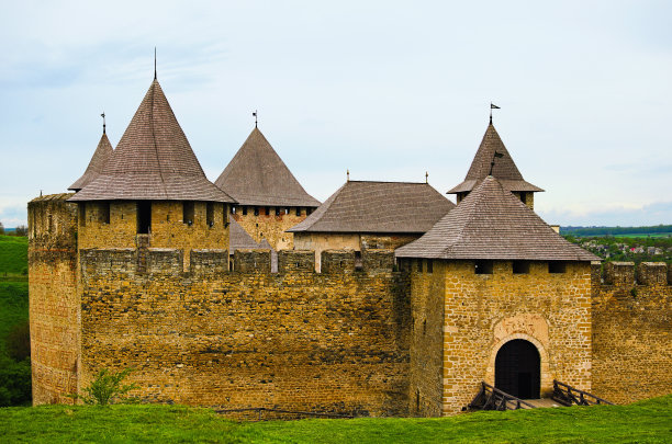 令人惊叹的中世纪城堡的景观照片，高石墙，防御塔和大门。蓝色的天空背景。低角度的观点图片下载