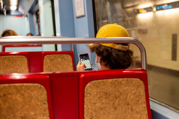 年轻人在地铁上玩手机的照片图片下载