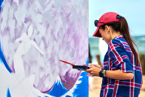 女画家在木板上作画，画抽象画、彩画、户外节庆图片下载