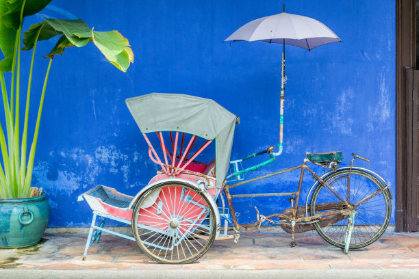 在槟城乔治城的蓝色大厦(昌发仔大厦)的黄包车的正面照片。图片下载