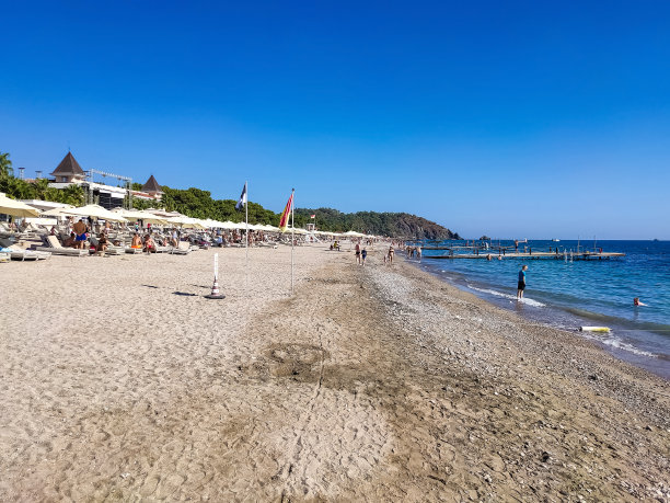 沙滩上的躺椅上有伞，躺椅上有山图片下载