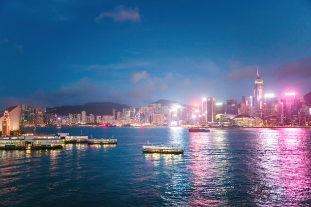 天星小轮夜间驶过维多利亚港。繁忙的商业区，著名的旅游地点在亚洲图片下载